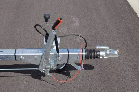 Elektrischer Hubantrieb mit Stellmotor, Kabel und Befestigungsteilen auf grauem Untergrund montiert.