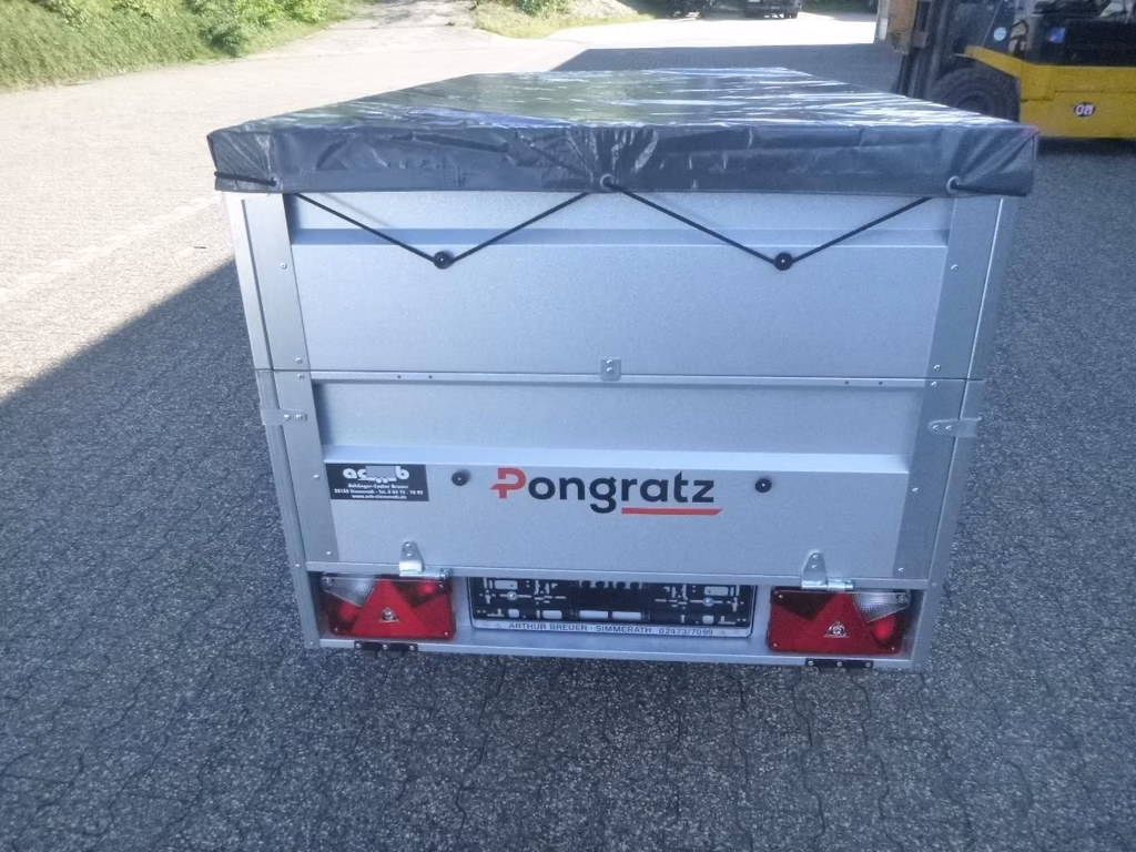 Pongratz Anhänger mit grauer Ladefläche, schwarzer Plane und roten Rückleuchten auf Asphalt.