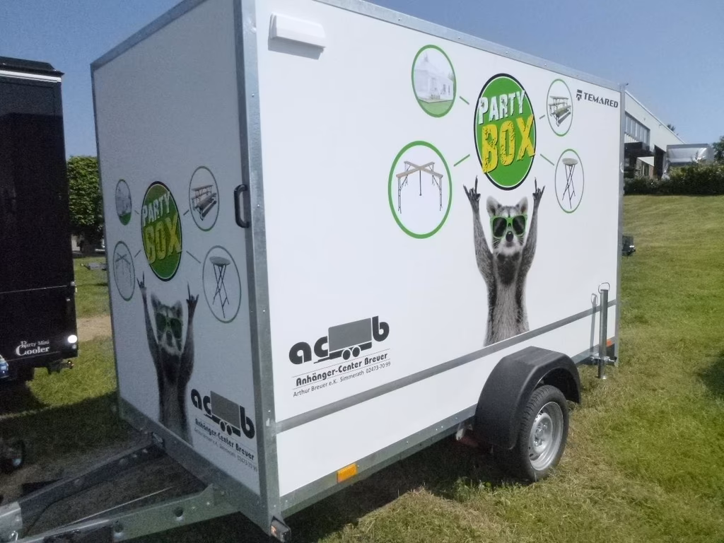 Weißer Anhänger mit "Party Box" Branding, Katzen-Grafik und grünen Symbolen für Partyzubehör von ACB Anhänger-Center-Breuer.